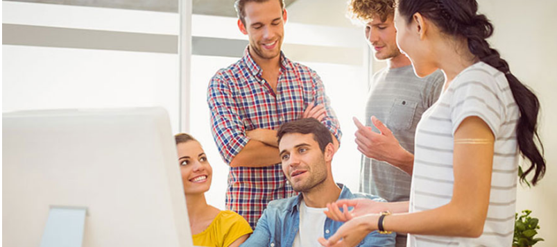 People Sitting in Front of a Computer Screen, Engaged in Discussion
